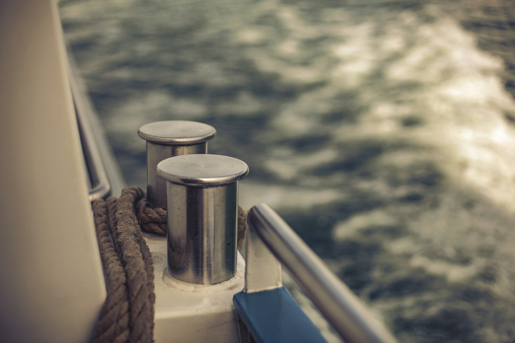 Polished stainless bollards and twisted rope on a yacht's stern rail